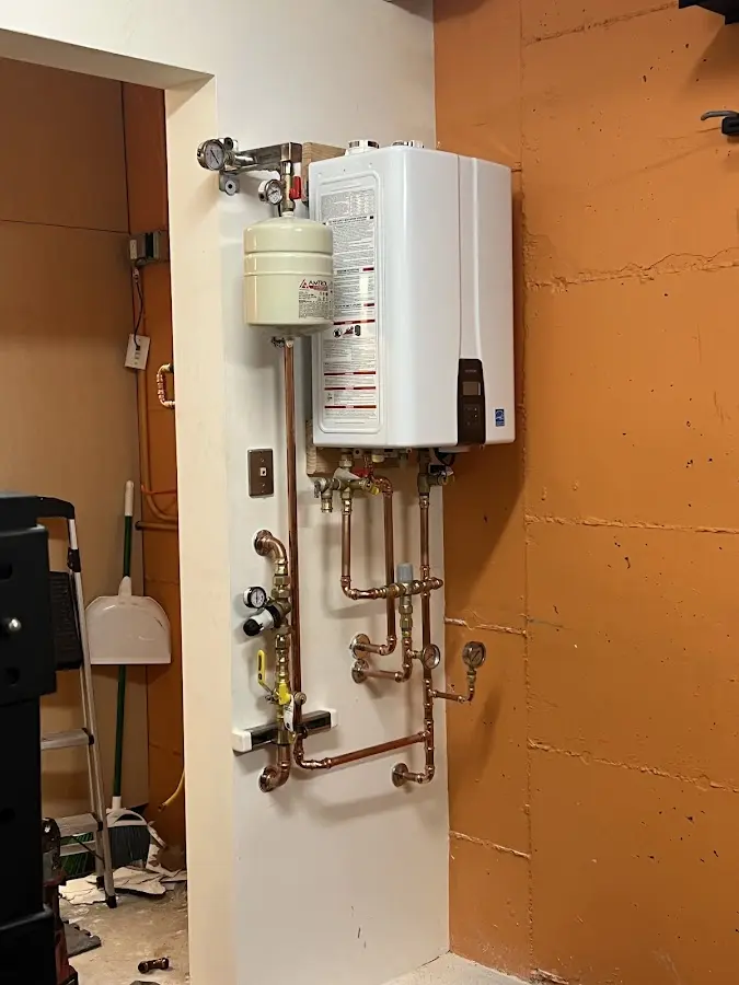 Plumbing technician inspecting water heater connections in Dunbarton